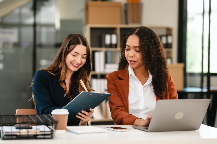 Two professional caucasian with african american businesswoman friends collaboration, working together at office, using laptop, Generally accepted audit standards, Earnings before interest and taxes