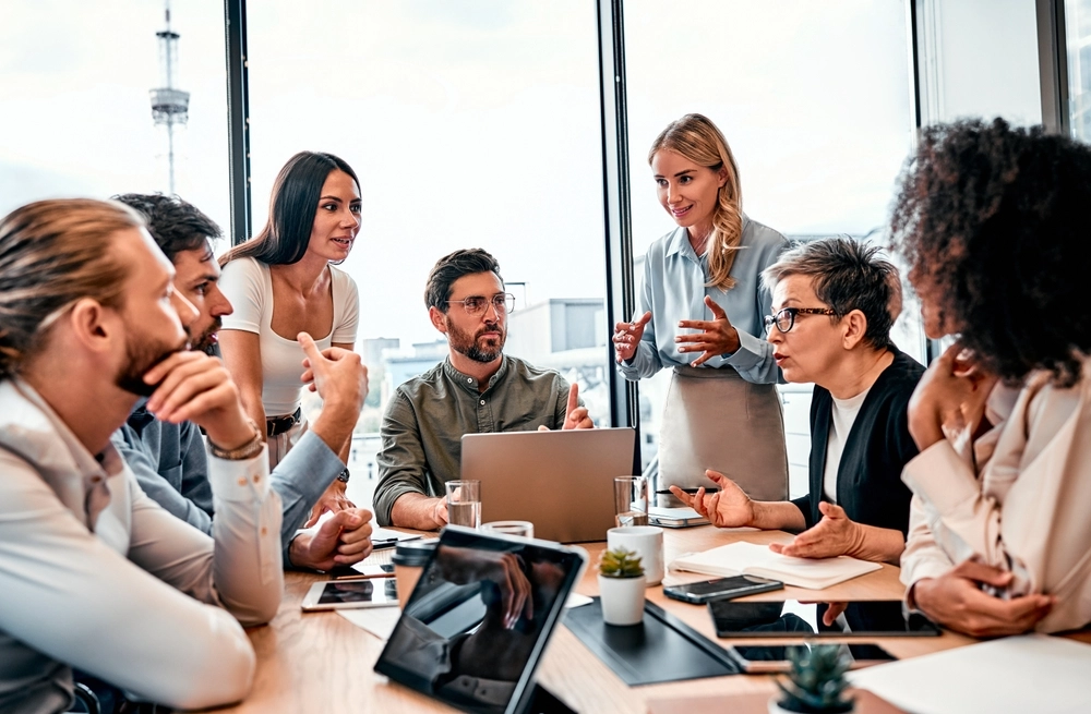 Good business idea. Inspired coworkers generating proposition for growing department's result. Enthusiastic women and men discussing project at meeting with excited facial expression.