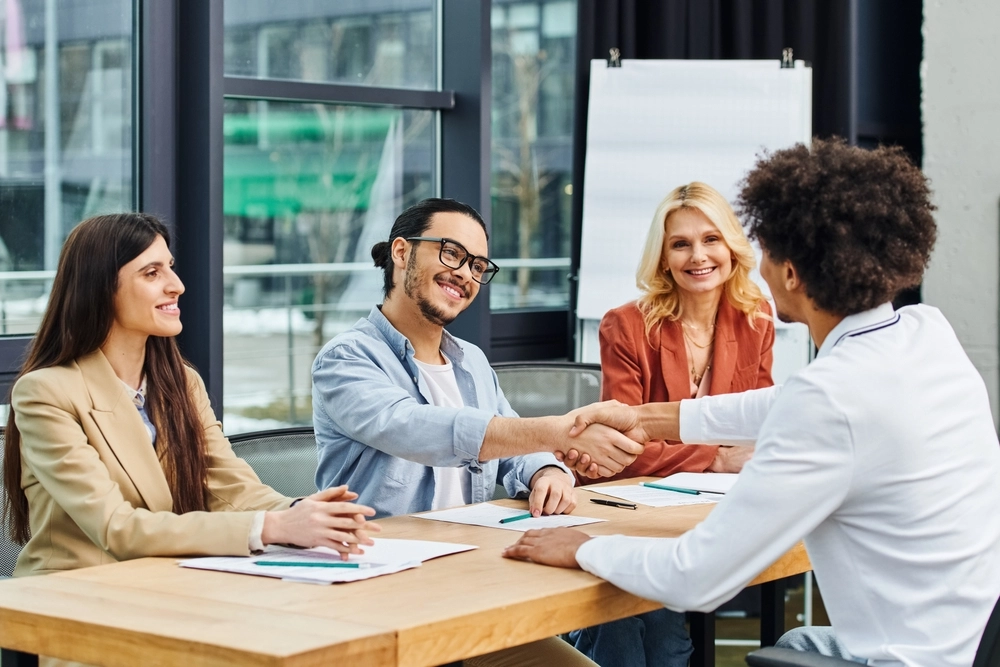 A group of job seekers shaking hands at a table during a successful networking session.