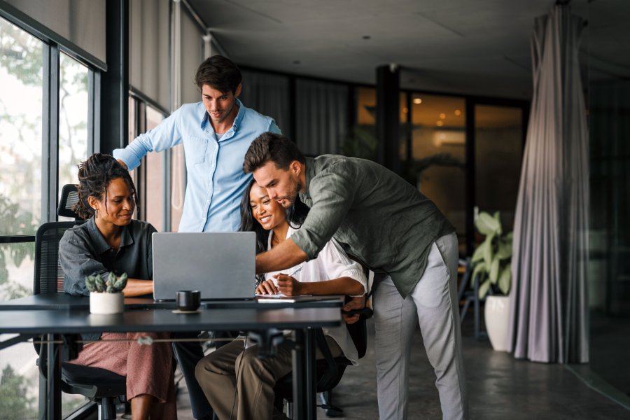 Multicultural professional businesspeople working together on research plan in boardroom.